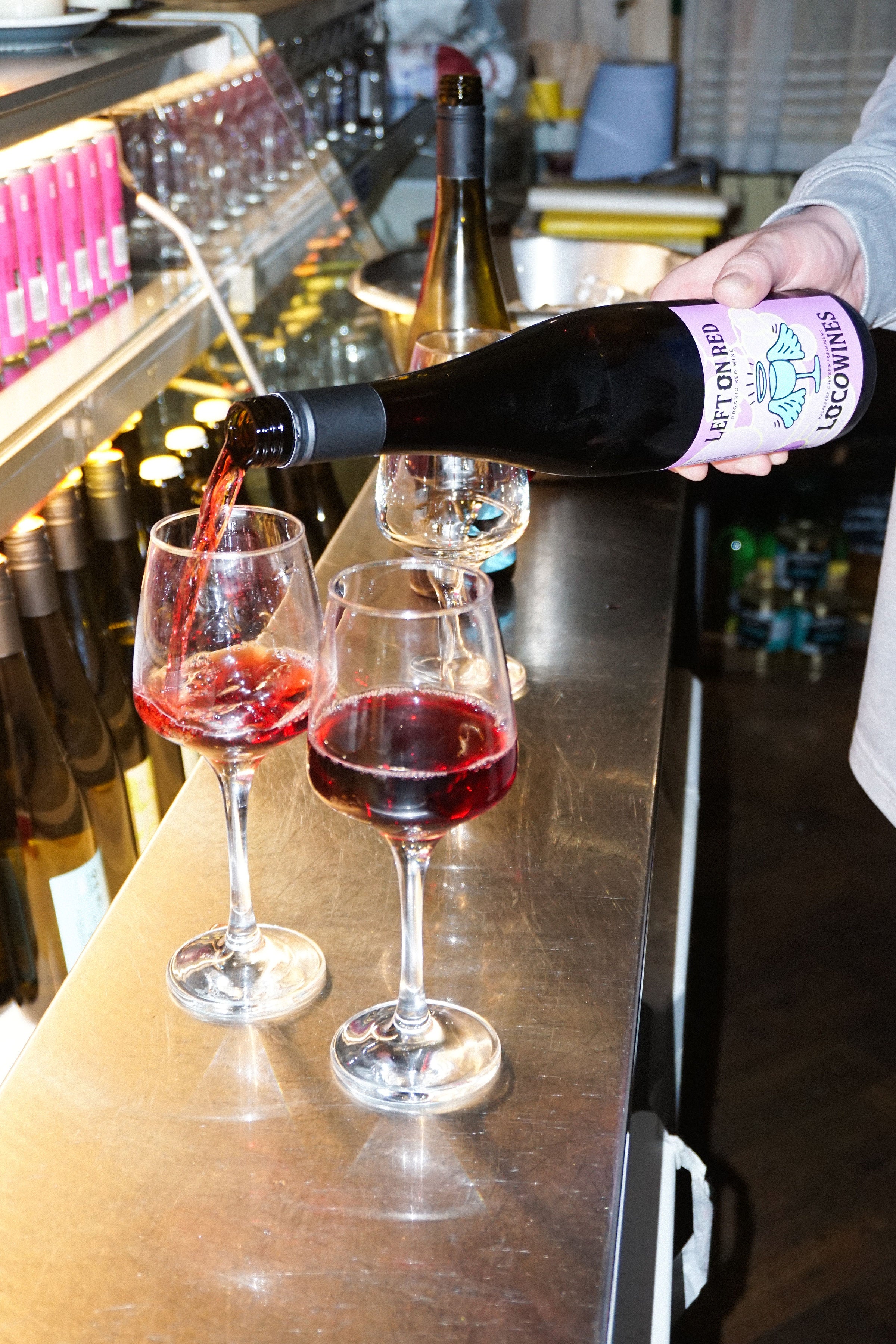 Left on Red easy drinking organic red wine being poured into glasses at a bar event by Loco Wines