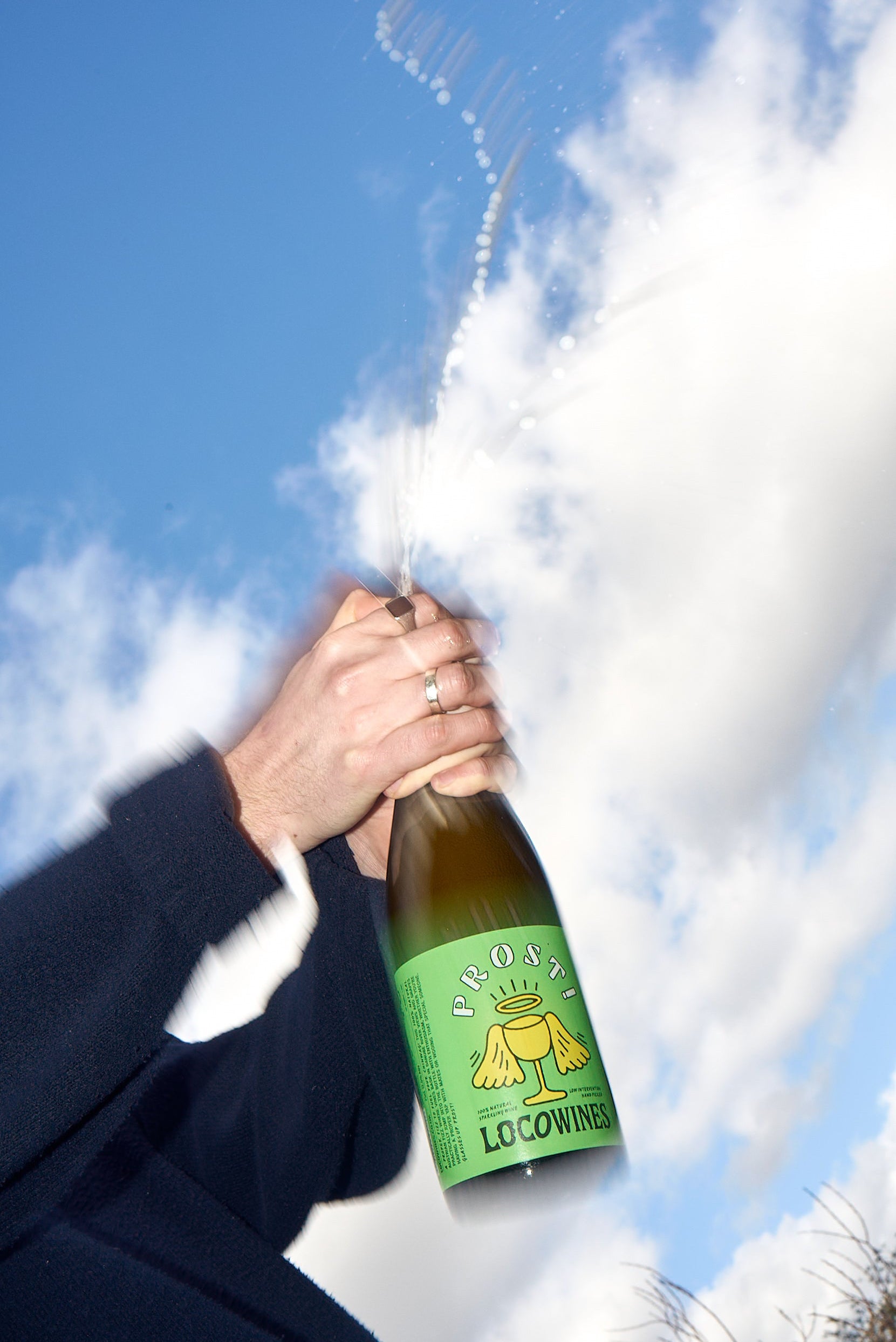 PROST! organic pét-nat sparkling wine bottle being opened with bubbles spraying against a blue sky by Loco Wines