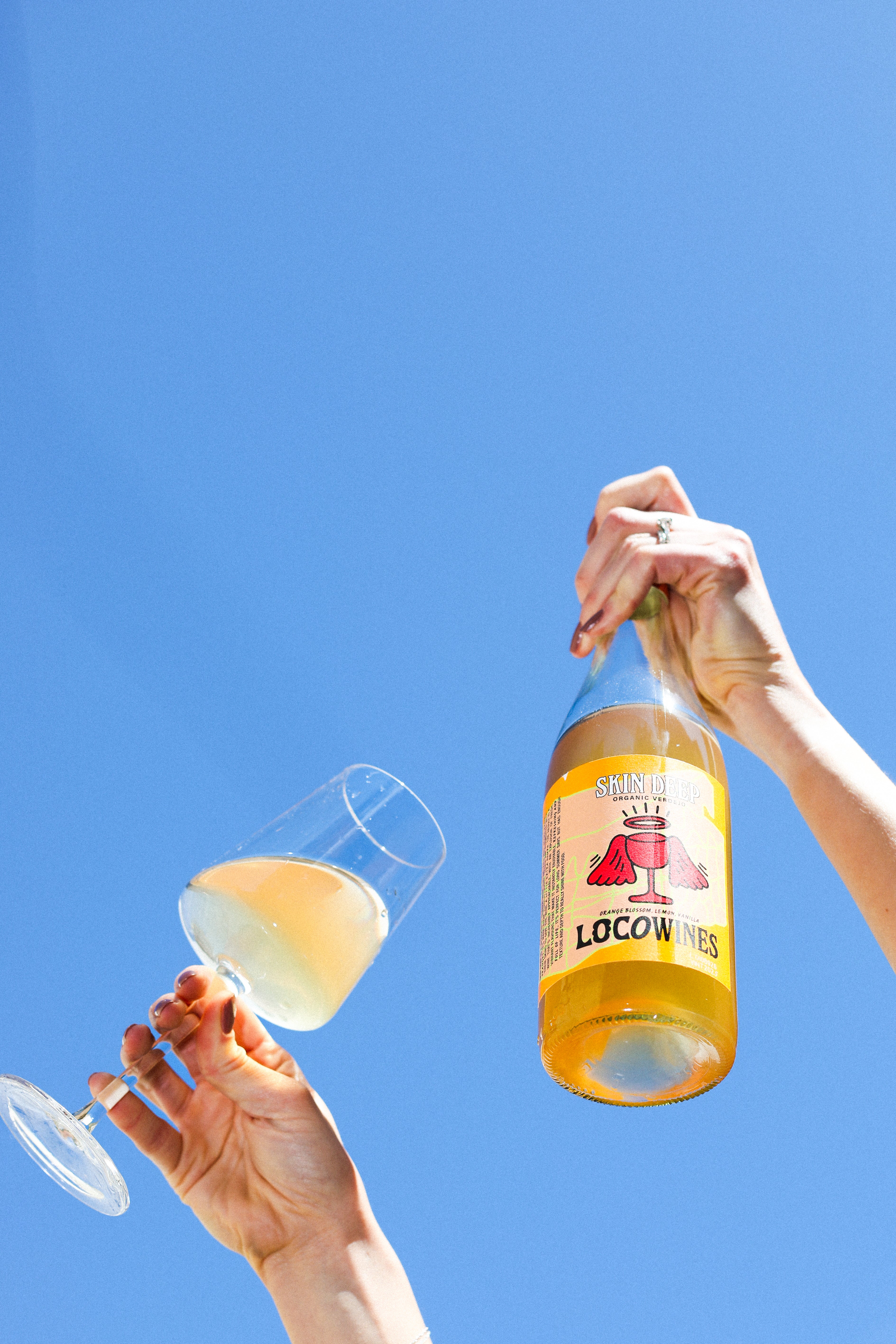 Loco Wines Skin Deep Orange Wine Skin Contact Wine being held in the air