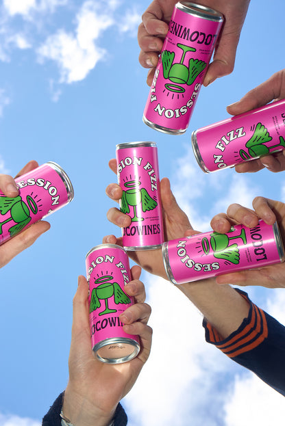 Group of people holding Session Fizz organic canned wine up to a blue sky at a festival by Loco Wines.