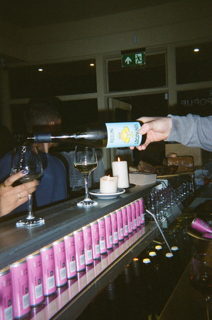 Loco Wines being served at a bar event with a row of pink cans lined up on the counter